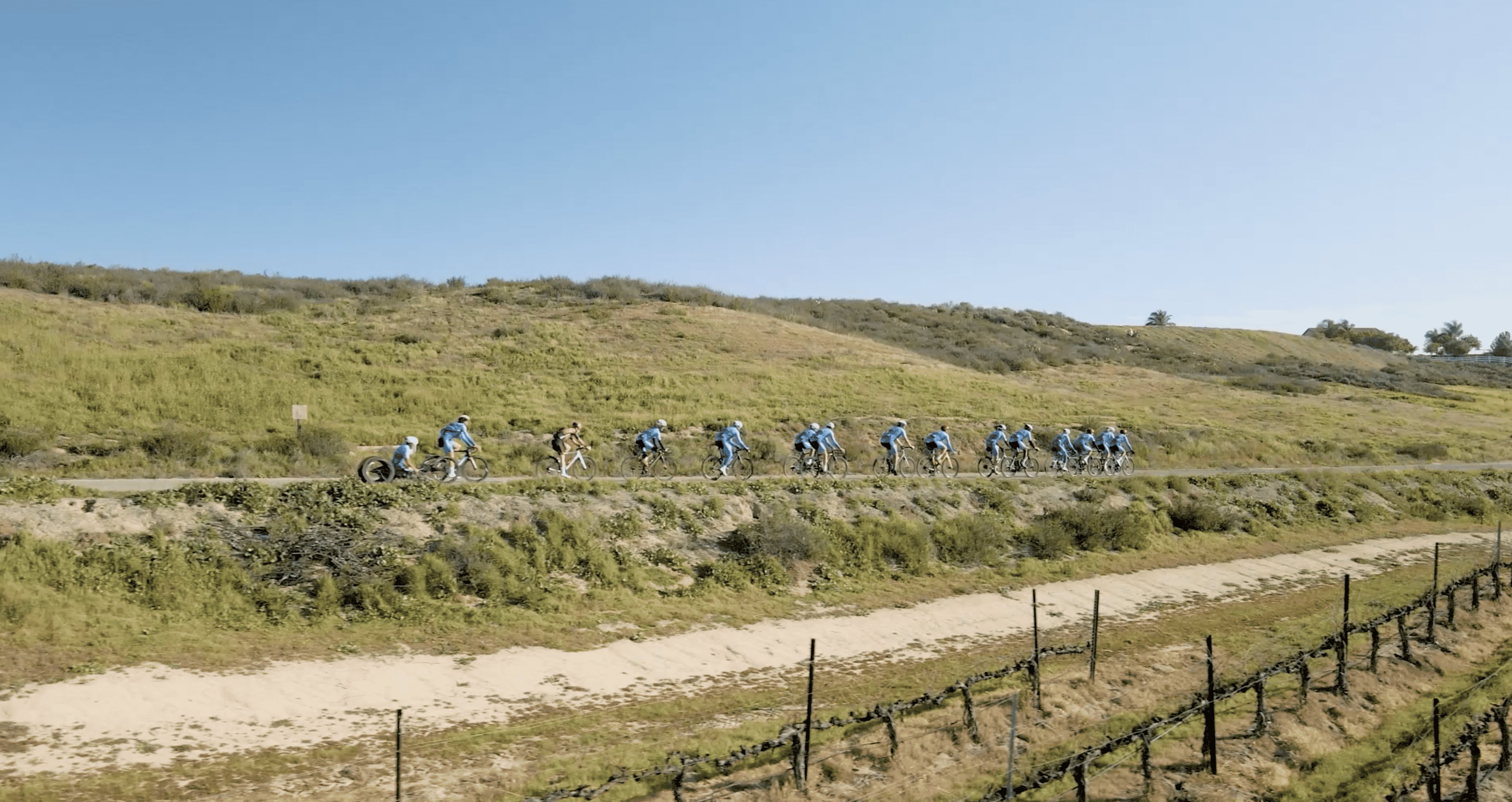 Peloton of iSpeed riders cycling through green hills in Temecula, California