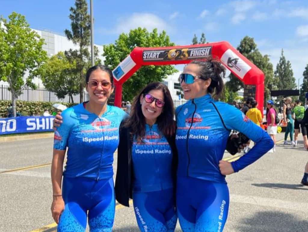 3 ispeed female cyclists posing with arms around each other