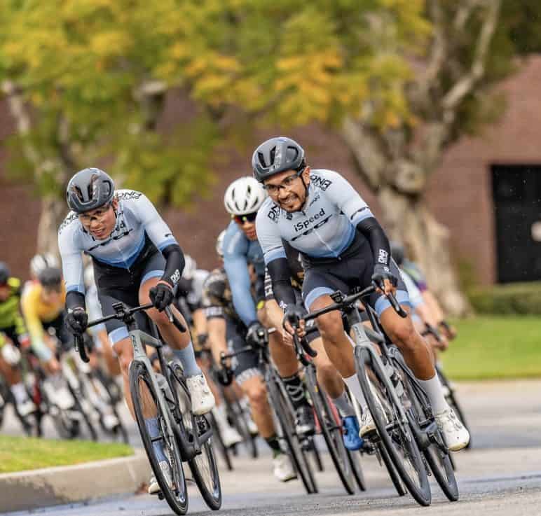 Thomas and Giovanni racing around a corner in front of peloton