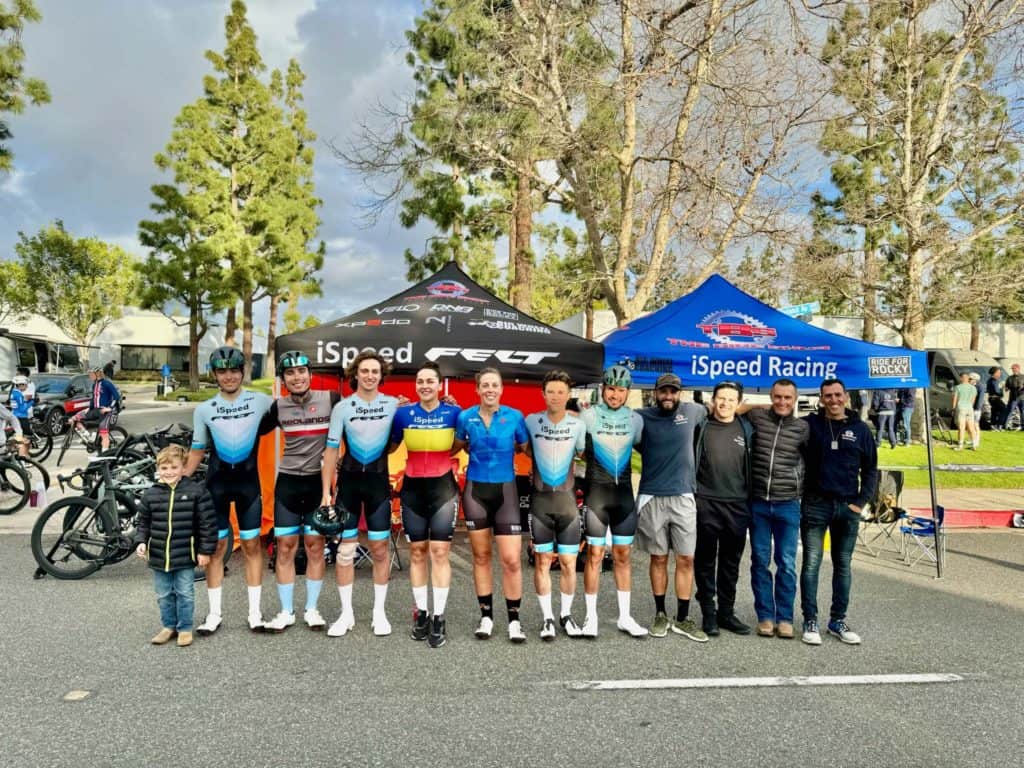 ispeed FELT racing cyclist team standing in a row posing for photo in front of ispeed tents at Costa Mesa crit race