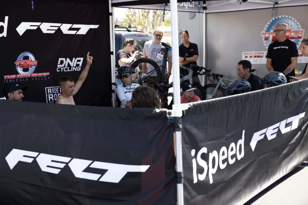 iSpeed Felt canopy and banners set up at Redlands Bicycle Classic with team inside talking before race